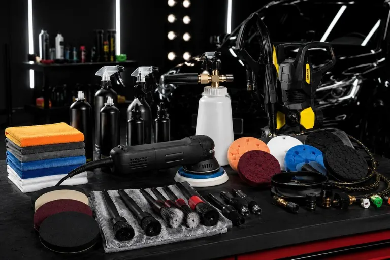 Professional detailer selecting paint correction compound and polishing pad for automotive detailing