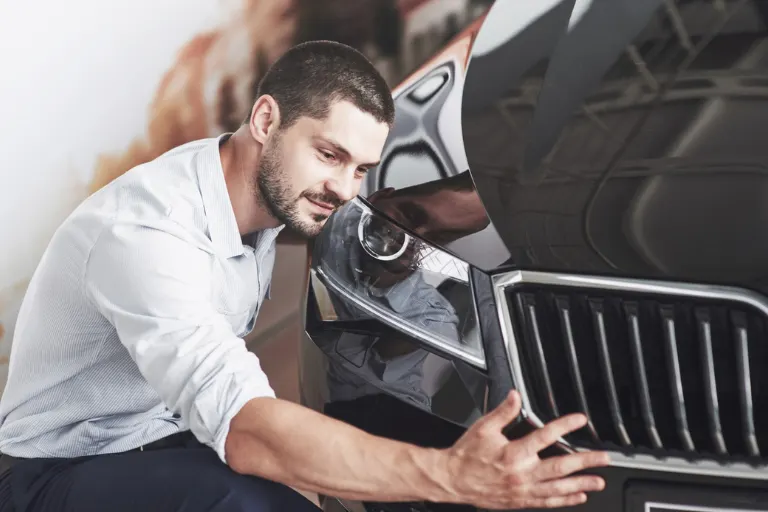 Professional automotive detailing team working on a luxury vehicle inside a modern detailing studio