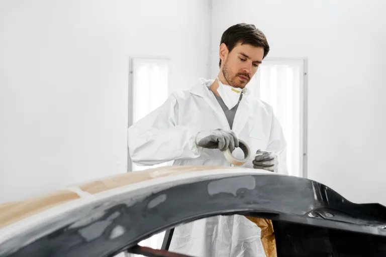 Professional detailer selecting the right compound for paint correction on a luxury vehicle under inspection lighting