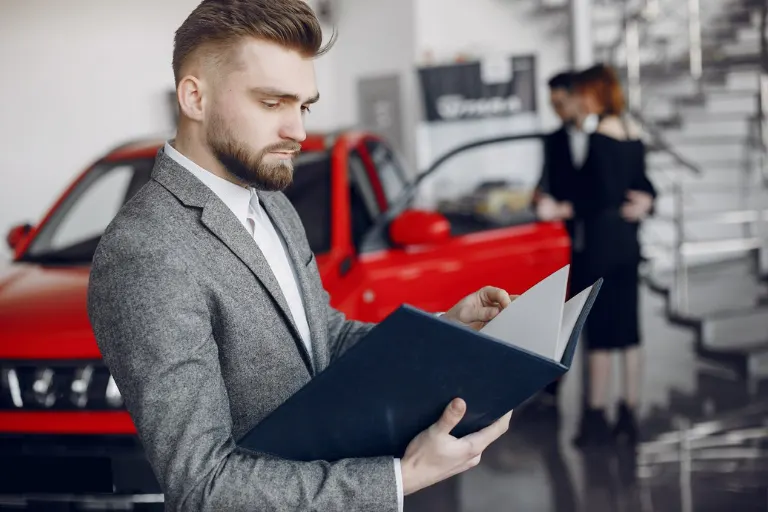 Professional detailer comparing automotive detailing brands and products inside a modern detailing studio