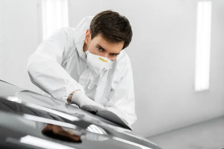 Organised detailing chemicals in a professional automotive detailing studio with clearly labelled bottles and safe storage practices.